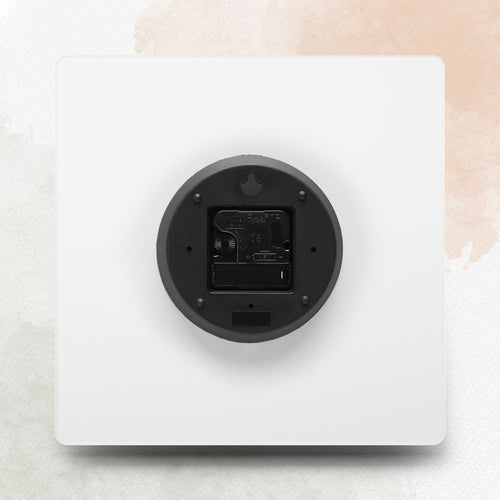 White electronic device with a black circular component on a light beige background