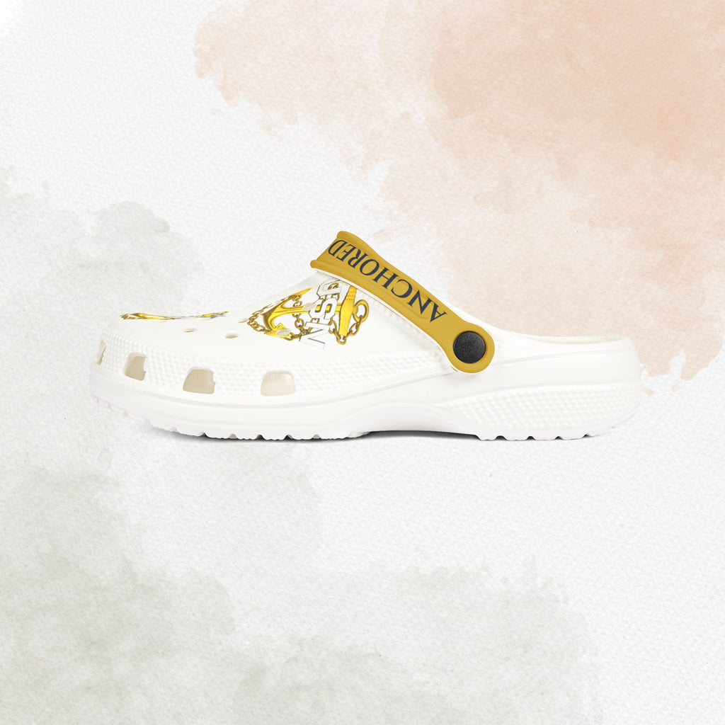 White clog shoe with gold strap and logo on a white background
