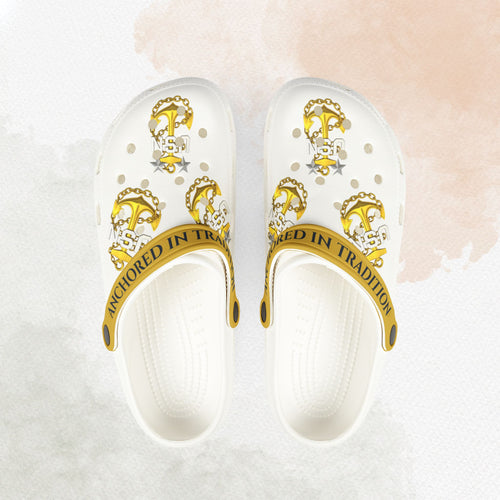 White sandals with gold accents and 'Inherited in Tradition' text on a light background